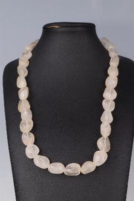 un collier composé de perles de quartz blanc enfilées sur un mannequin noir