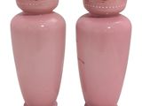 two pink vases sitting next to each other on a white surface
