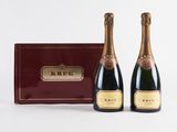 two bottles of champagne in front of a red box