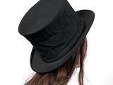 a woman wearing a black top hat and a white shirt