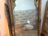 a large mirror sitting on the floor next to a shelf