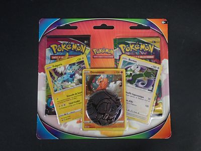 deux cartes Pokémon et une pièce de monnaie posées sur une table