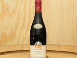 une bouteille de vin posée sur un tonneau en bois