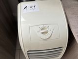 a small air conditioner sitting on the floor next to a desk