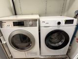 two washers and a dryer in a small room