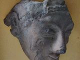 a stone head on the wall of a building