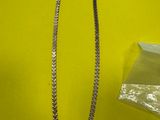 un collier et une paire de ciseaux posés sur une table jaune