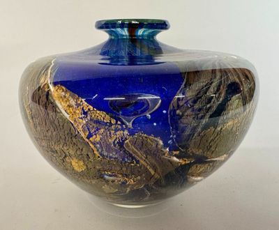 un vase en verre bleu orné d'un motif à la feuille d'or