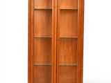 une armoire en bois avec des portes vitrées et des étagères au-dessus