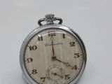 a silver pocket watch on a white surface