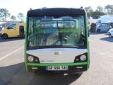 a green and white bus that is parked in a parking lot
