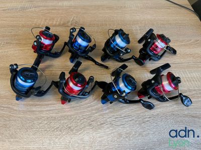 tout un tas de moulinets de pêche posés sur la table