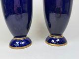 pair of blue vases with gold rims sitting on a white surface