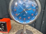 a blue clock sitting on top of a table next to a red clock