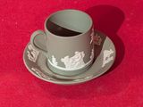 une tasse et une soucoupe posées sur une soucoupe, le tout sur une surface rouge