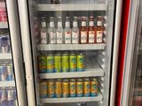 two refrigerators that have drinks in them in a store