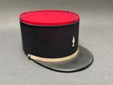 chapeau haut-de-forme noir et rouge orné d'une bande dorée sur fond gris