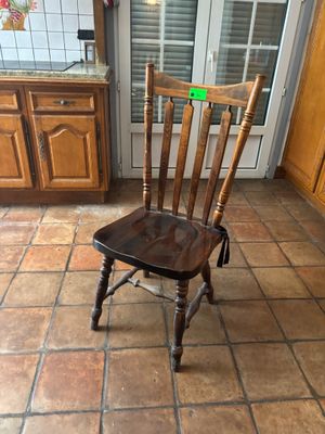 une chaise en bois posée au milieu du sol de la cuisine