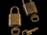 deux vieux cadenas en laiton et une clé sur fond noir