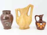 three vases sitting next to each other on a white surface