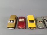 several toy cars are lined up in a row on a gray surface