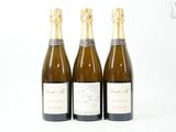 trois bouteilles de vin posées les unes à côté des autres sur une surface blanche