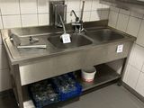 une cuisine avec un évier et beaucoup de vaisselle