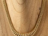 a close up of a gold chain necklace on a mannequin mannequin
