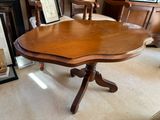 une table en bois dont le plateau a la forme d'une fleur, au milieu d'un salon