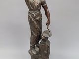 statue of a man holding a hammer and a hammer in his hand