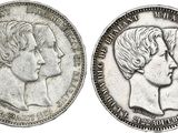 une pièce d'argent sur laquelle figurent les visages de deux femmes et d'un homme