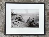 une photo en noir et blanc de deux voitures anciennes sur une piste