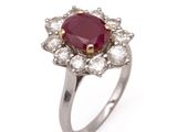 gros plan d'une bague avec une pierre rouge entourée de diamants blancs