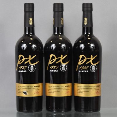 three bottles of red wine sitting on top of a glass table