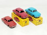 three toy cars are sitting in a box on a white surface