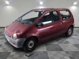 une petite voiture rouge garée sur un sol à damier
