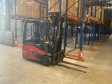 a forklift in a large warehouse with pallets on the floor