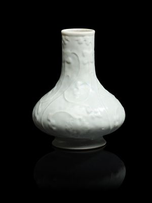 un vase blanc posé sur une surface noire