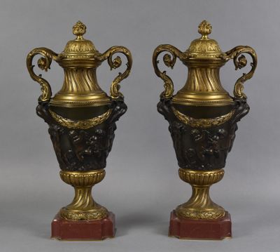 paire de vases en bronze et noir reposant sur des socles en marbre rouge