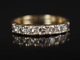 une bague en or jaune sertie de cinq diamants sur un fond noir