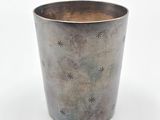 une coupe en argent ornée d'étoiles, posée sur une surface blanche