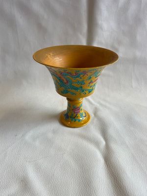 un vase jaune orné d'un motif bleu et vert