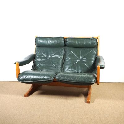 un canapé en cuir vert posé sur un sol recouvert de moquette