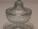 a small glass bowl with a lid on a saucer