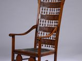 un vieux fauteuil à bascule avec une structure en bois et une assise en cuir