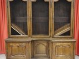 an old wooden bookcase with glass doors and shelves on a tiled floor