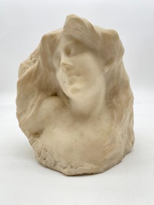 sculpture représentant la tête d'une femme sur un rocher, sur fond blanc