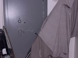 a coat hanging on a hook in the corner of a room