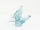 an image of a glass bird figurine sitting on top of a white surface