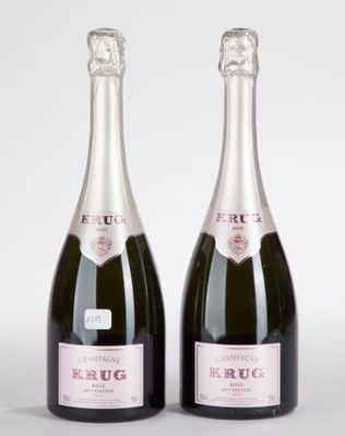 deux bouteilles de champagne posées l'une à côté de l'autre sur une surface blanche
